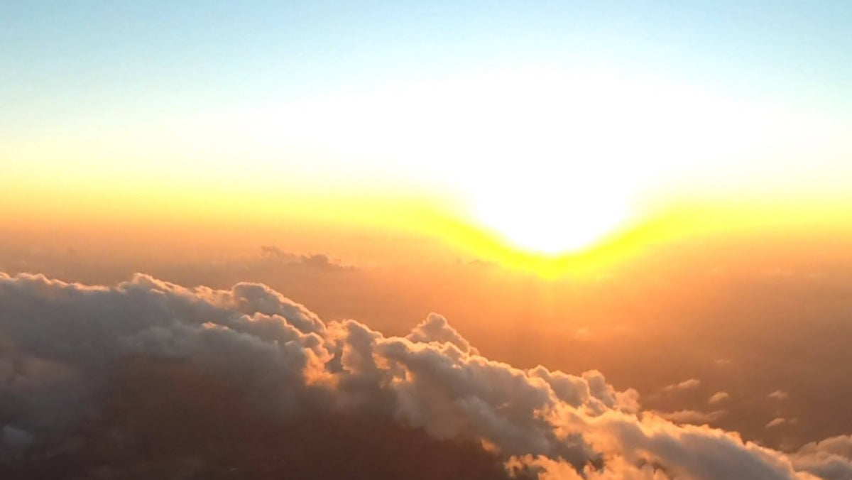 Aerial view of a breathtaking sunset over clouds from 10,000 feet above ground.