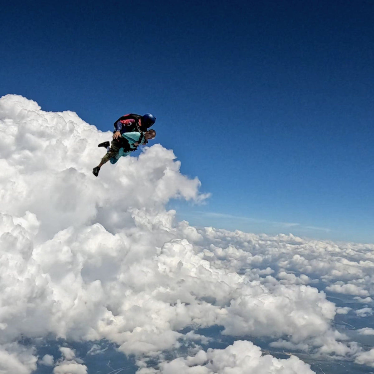 Exhilarating tandem skydive during freefall, surrounded by clouds.